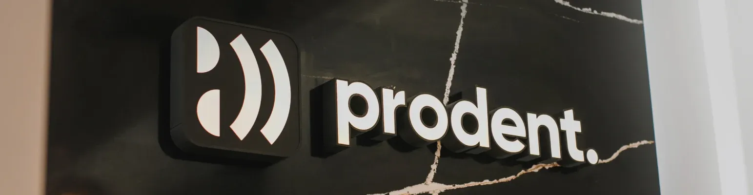 The white ProDent logo on a dark marble wall inside the clinic