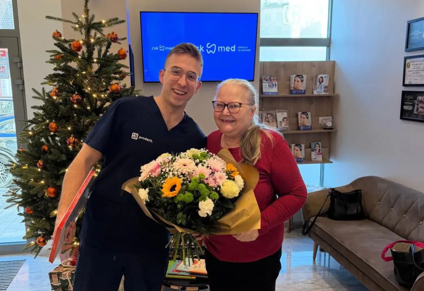 A ProDent team member and a patient holding flowers at reception